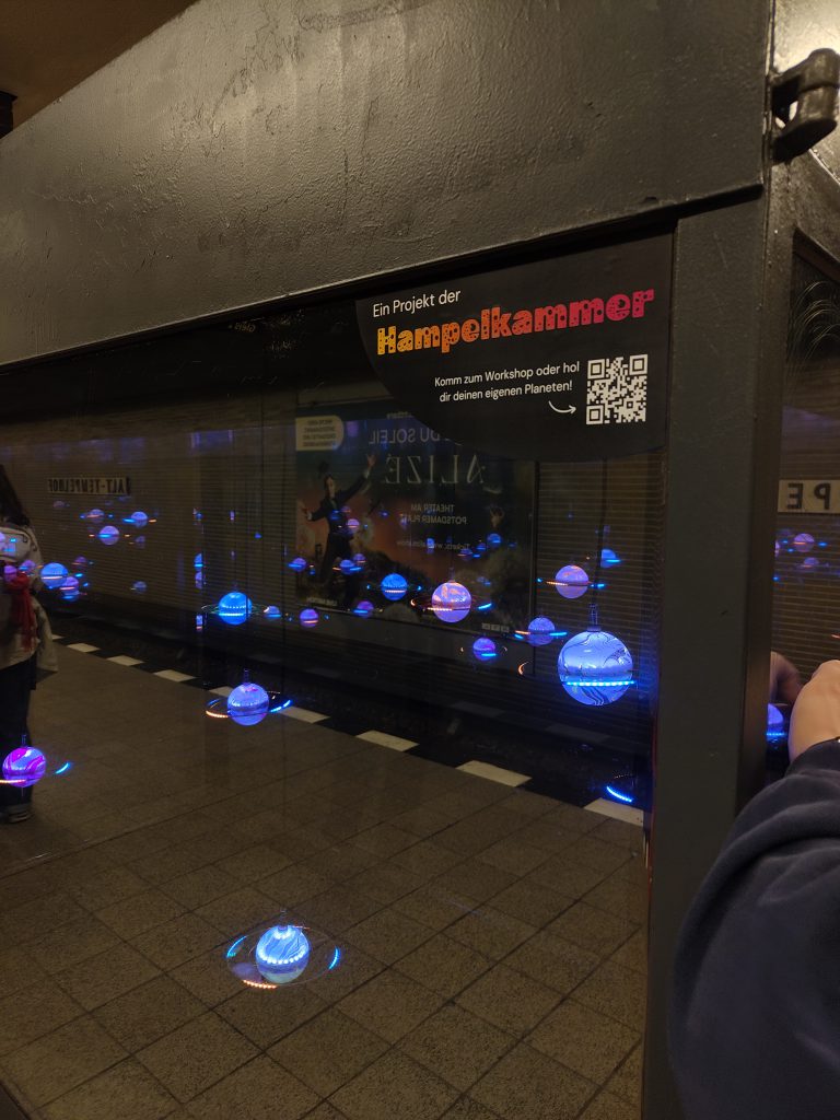 Traumraum Alt-Tempelhof – verspiegelte Vitrine mit schwebenden Planeten